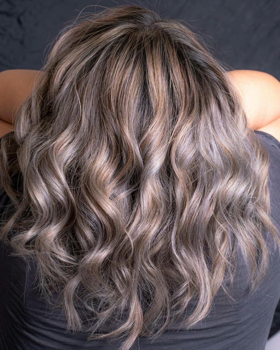 Cheveux mi-longs ondulés aux reflets beige cendré